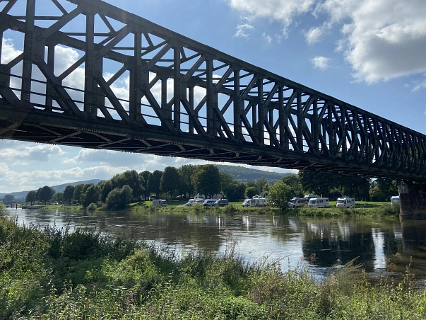 Ansicht Wohnmobilstellplatz von der anderen Weserseite Auf dem Bild ist der Wohnmobilstellplatz „Am Mühlentor“ in Bodenwerder zu sehen, dieser liegt am Ende der Fußgängerzone und direkt an der Weser.
Auf dem Bild ist der Blick von der gegenüberliegenden Weserseite auf den Stellplatz zu sehen. Hierbei ist auch die Eisenbahnbrücke oberhalb des Stellplatzes eingefangen worden. © Samtgemeinde Bodenwerder-Polle