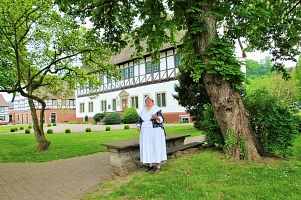 Frau Nolte ist die Haushälterin Münchhausen und ist die zentrale Figur, wenn es um eine Erlebnisführung durch Bodenwerder geht. 
Mit ihrem weißen Gewand steht sie unter einem Baum im Rathauspark in Bodenwerder und lädt mit ihrer Hand ein zu vielen tollen Geschichten. 
Im Hintergrund ist die Geburtsstätte des Münchhausenbarons also das Rathaus zu sehen. 
Hinter Frau Nolte befindet sich eine Holzbank mit einem Steintisch.
Hinter Erlebnisführerin Nolte befindet sich das Rathaus sowie links daneben das urige Brennereihaus.&nbsp;&copy;&nbsp;Samtgemeinde Bodenwerder-Polle