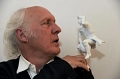 Herman Van Veen hat den Münchhausenpreis auf seiner linken Schulter abgestellt und blickt auf diesen. Er trägt ein schwarzes Sakko über einem weißen offenen Hemd.&nbsp;&copy;&nbsp;Thorsten Sienk