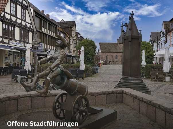 Offene Stadtführungen.jpg Der große Münchhausen- Brunnen in der Fußgängerzone in Bodenwerder wurde 1994 von Bonifatius Stirnberg aus Aachen erschaffen.
Dieser Brunnen zeigt drei der bekanntesten Münchhausengeschichten mit dem Pferd am Kirchturm, der Entenflug sowie der Ritt auf der Kanonenkugel.
Das Pferd am Kirchturm erzählt über die Geschichte als sich der Baron von Münchhausen auf dem Weg nach Russland im tiefsten Winter mit seinem Pferd zum Schlafen niederließ. Als er am nächsten Tag erwachte hing das Pferd mitten auf dem Kirchplatz am Kirchturm.
Beim Entenflug ging es darum, dass der Baron Enten schießen wollte am See. Durch einen raffinierten Trick hatte er alle Enten an einer Leine, so dass keine wegfliegen konnte. Er wollte sie mit nach Hause nehmen, doch auf dem Weg dahin flogen sie mitsamt Münchhausen wieder Richtung See.
Der Ritt auf der Kanonenkugel handelt davon, dass ein Marschall im Feldzug wissen wollte wie es in einer Festung aussah. Deshalb stellte sich Münchhausen neben eine Kanone und wartete bis die nächste Kugel heraus kam um auf sie zu springen. Somit flog er mit der Kanonenkugel in die Festung.
Von dem Münchhausen- Brunnen aus hat ist im Hintergrund die Sicht auf die St. Nicolai Kirche gegeben. © Samtgemeinde Bodenwerder-Polle/Rolf Sander