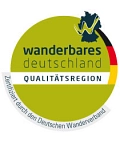 Das Logo hat die Grundfarbe grün und ist rund. Auf dem grünen Hintergrund befindet der blaue Schriftzug "wanderbares Deutschland! und auf einem weißen Streifen "Qualitätsregion". Rechts oben ist in dunkelblau der Umriss von Deutschland mit einem grünen "w", welches eine weiße verschobene Umrandung hat. Außerdem befinden sich an der rechten oberen Seite die Farben der Deutschlandflagge. Unten an dem Kreis ist ein hellgraues Band mit der Inschrift "Zertifiziert durch den Deutschen Wanderverband".&nbsp;&copy;&nbsp;Deutscher Wanderverband Service GmbH