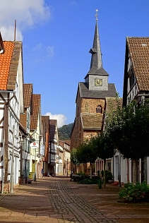 Anfang des 15. Jahrhunderts wurde die Stadtkirche St. Nicolai in Bodenwerder als dreischiffige gotische Hallenkirche und dem Heiligen Nikolaus geweiht. Erwähnt wird eine St-Nikolaus-Kapelle allerdings bereits im Jahr 1245, dies könnte die Vorgänger-Kirche gewesen sein. Die steinernen Fundamente dieser St-Nikolaus-Kapelle wurden bei archäologischen Ausgrabungen in den Jahre 1984 und 1985 gefunden. 
Die heutige St-Nikolaus-Stadtkirche wurde mit Bruchsteinmauerwerk errichtet und mit einem Fachwerkgiebel im Osten ausgestattet. Im Jahr 1900 würde das Gebäude „gesüdet“, wobei eine nötige Vergrößerung mit einem Anbau im Süden für den heutigen Altarraum durchgeführt wurde. Im Zuge dieses Anbaus wurde der Haupteingang der Kirche auf die Nordseite der Kirche verlegt, wodurch sich die damals übliche Ost-West Ausrichtung der Kirche änderte. 
Aufgrund von ständig wiederkehrendem Hochwasser in Bodenwerder wurde im 19. Jahrhundert neben dem Straßenniveau auch der Boden der Kirche um mehr als einen Meter höher gelegt. In den 1960er Jahren wurde die Stadtkirche im Inneren renoviert und bekam ihr heute noch bestehendes modernes Erscheinungsbild.
 Das imposante Kirchenfenster, welches das letzte Abendmahl darstellt, wurde von dem Bremer Glasmacher Heinz Lilienthal erstellt. Der von dem einheimischen Künstler Bruno Schmitz erstellte Altar aus Dolomitgestein wurde auf diese Kirchenfenster abgestimmt. Auch die Bronzeplatten an der Kanzel und dem Betpult, an der Decke des Taufbeckens, der Osterleuchter sowie das Altarkreuz wurden von Bruno Schmitz angefertigt. 
Die Glocke im Kirchturm stammt aus dem Jahre 1471 und ist somit die älteste Glocke im gesamten Kirchenkreis. Da die Glocke als einzige nicht in den Kriegen eingeschmolzen wurde, kann sich noch heute mit zwei neueren Glocken Freud und Leid verkünden.&nbsp;&copy;&nbsp;Samtgemeinde Bodenwerder-Polle - Horst Kumpf